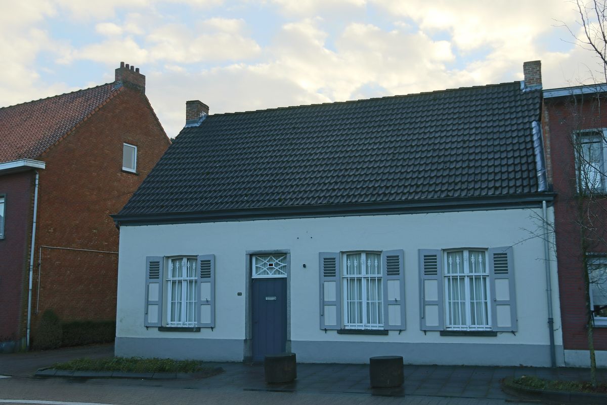 Een witte woning met grijze luiken in Bevel-Dorp
